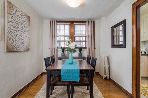 a dining room with a wooden table and chairs