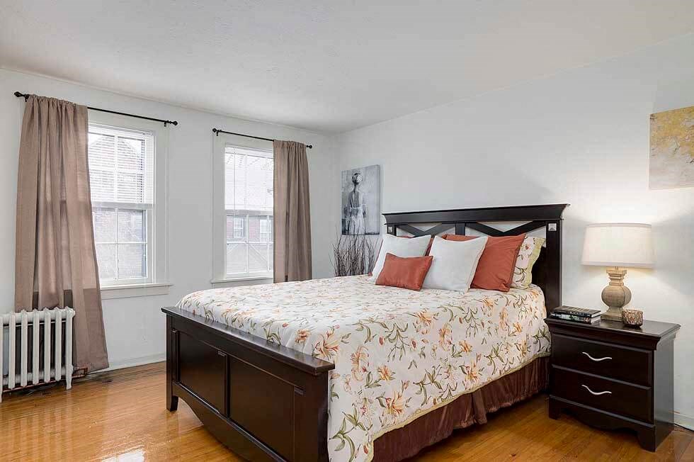 a bedroom with a bed and two windows