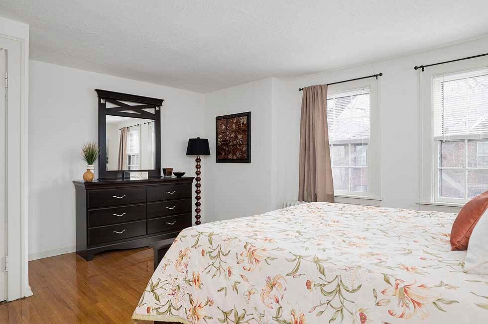 a bedroom with a bed and a black dresser