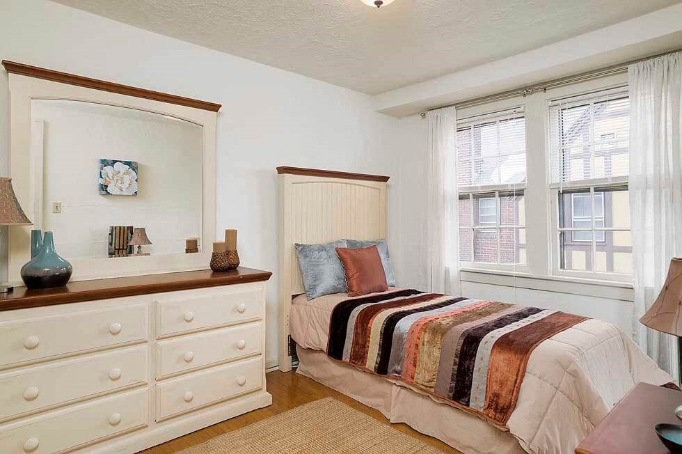 a bedroom with a bed and a mirror