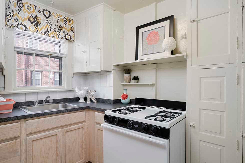 a white kitchen with a stove and a sink