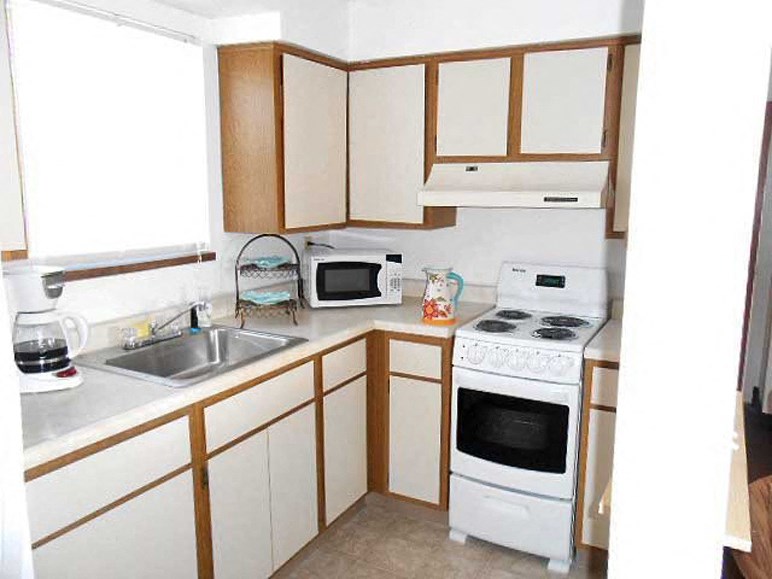 a small kitchen with a stove microwave and sink