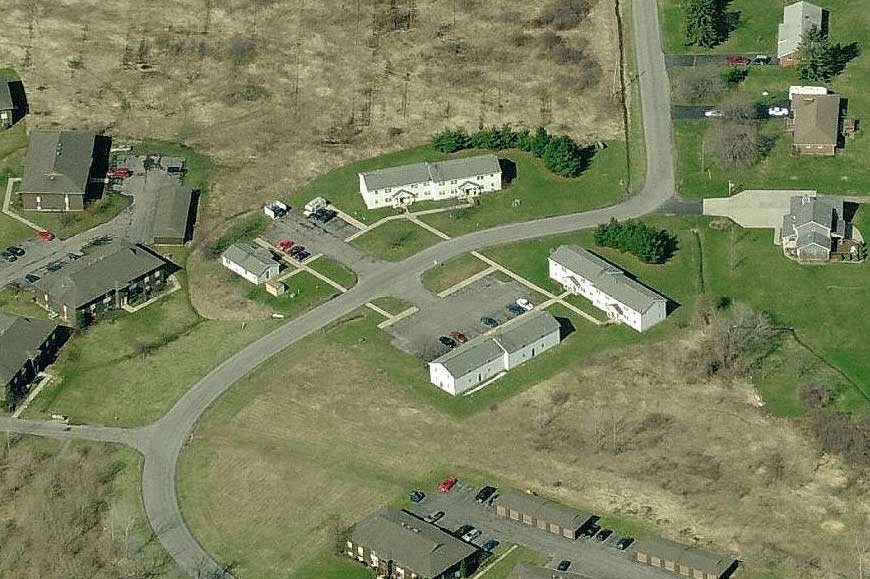 an aerial view of a neighborhood with houses and a road