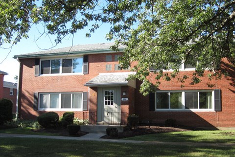 A red brick house with a white door and windows.