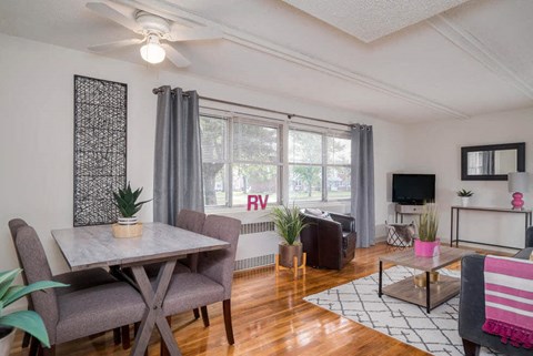 A living room with a dining table and chairs.