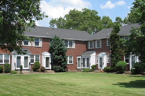 a large brick house with a green lawn