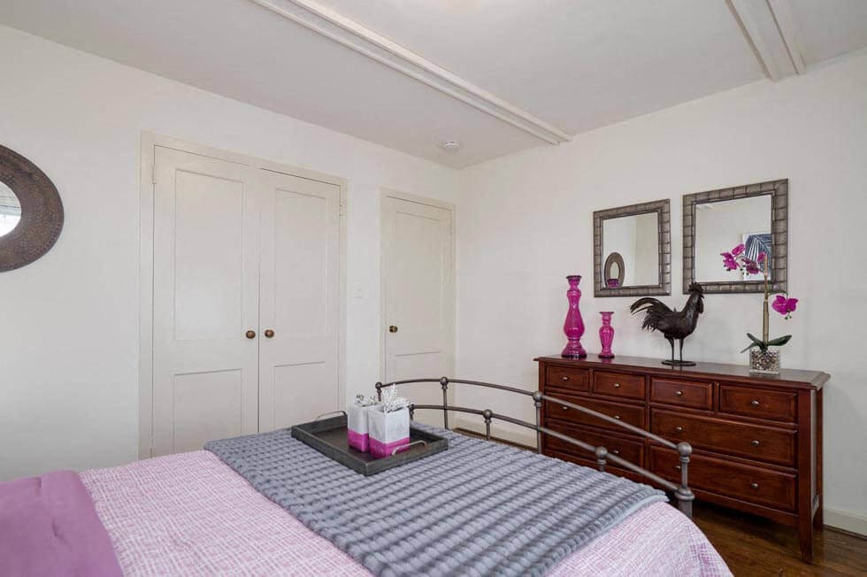 a bedroom with a bed and a dresser and two doors