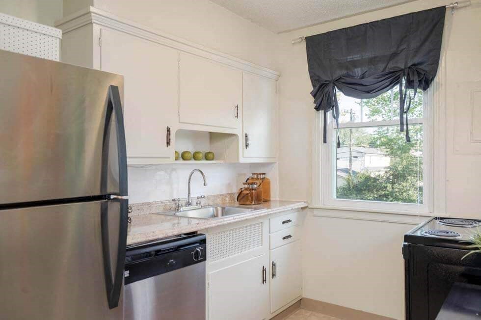 a kitchen with a sink and refrigerator and a window