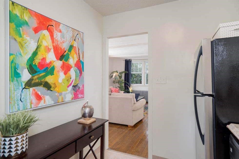 a living room with a tv and a painting on the wall