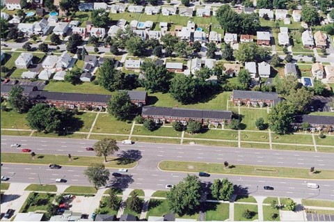 an aerial view of a neighborhood with cars on a road