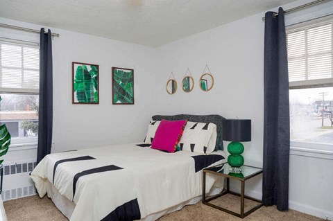 a bedroom with a bed and two windows