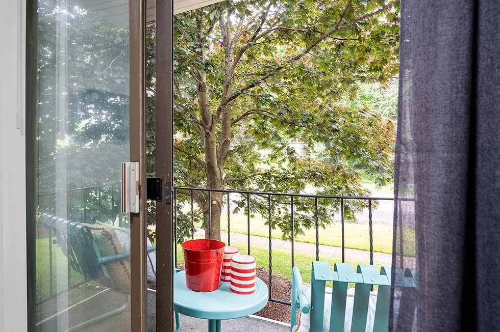 a balcony with a table and chairs and a tree