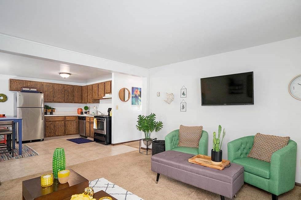 a living room with a couch and a chair and a kitchen