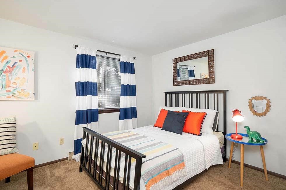 a bedroom with a bed and a chair and a table