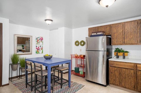 a kitchen with a blue table and a stainless steel refrigerator