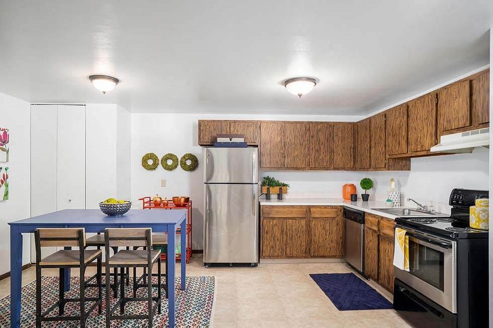 a kitchen with a blue table and a stainless steel refrigerator