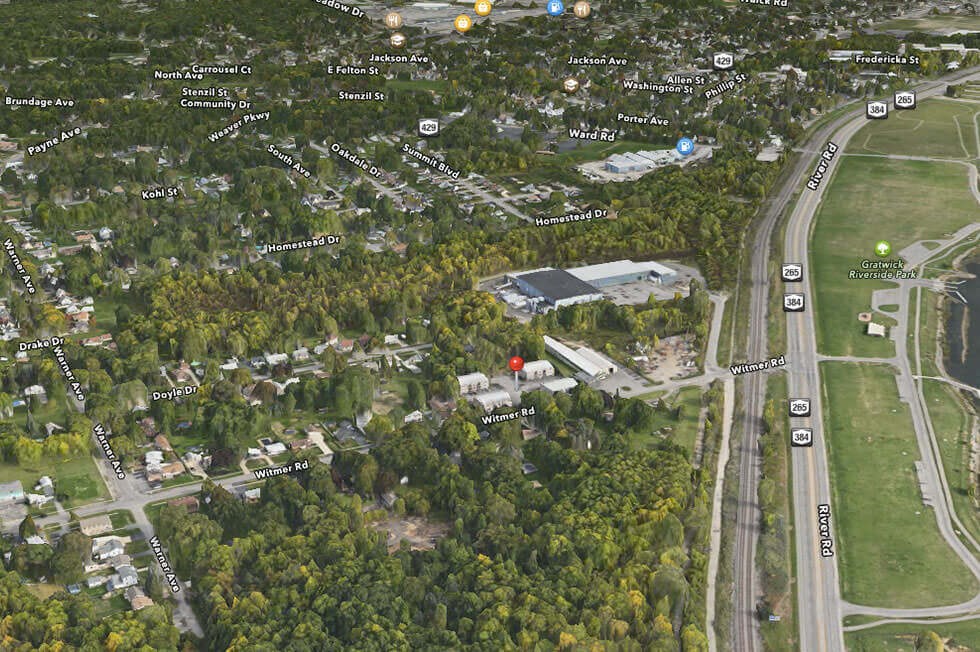 an aerial view of a city with a road and trees