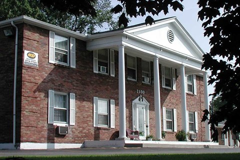 a brick building with columns and a sign on the front