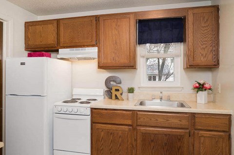 a kitchen with white appliances and wooden cabinets