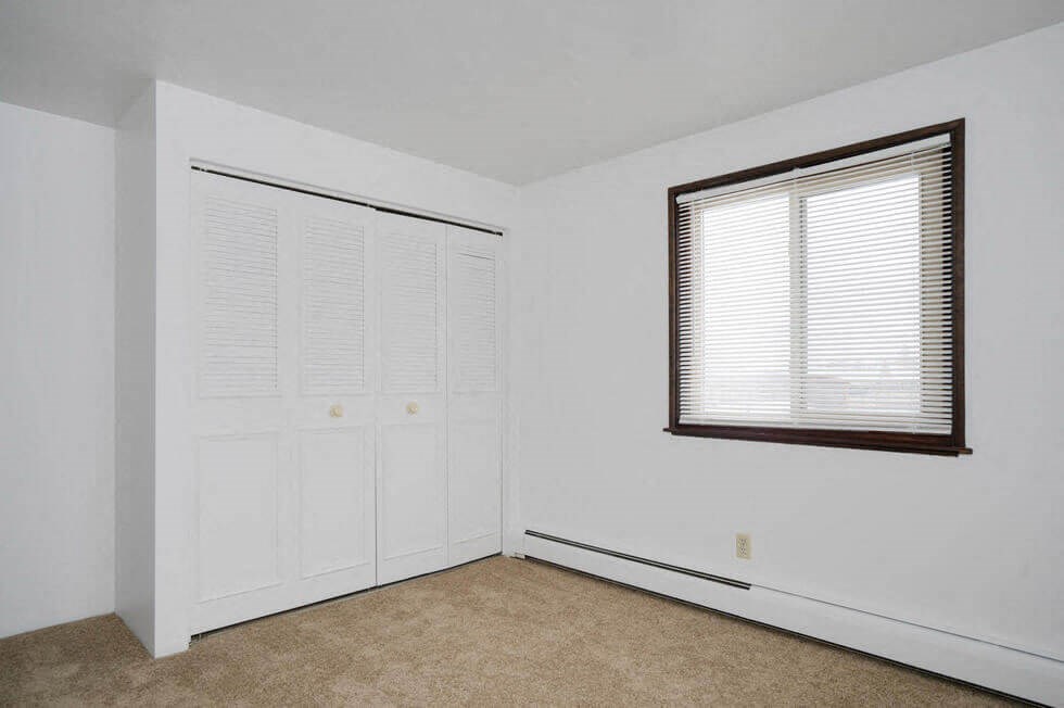 an empty room with white walls and a window and a door