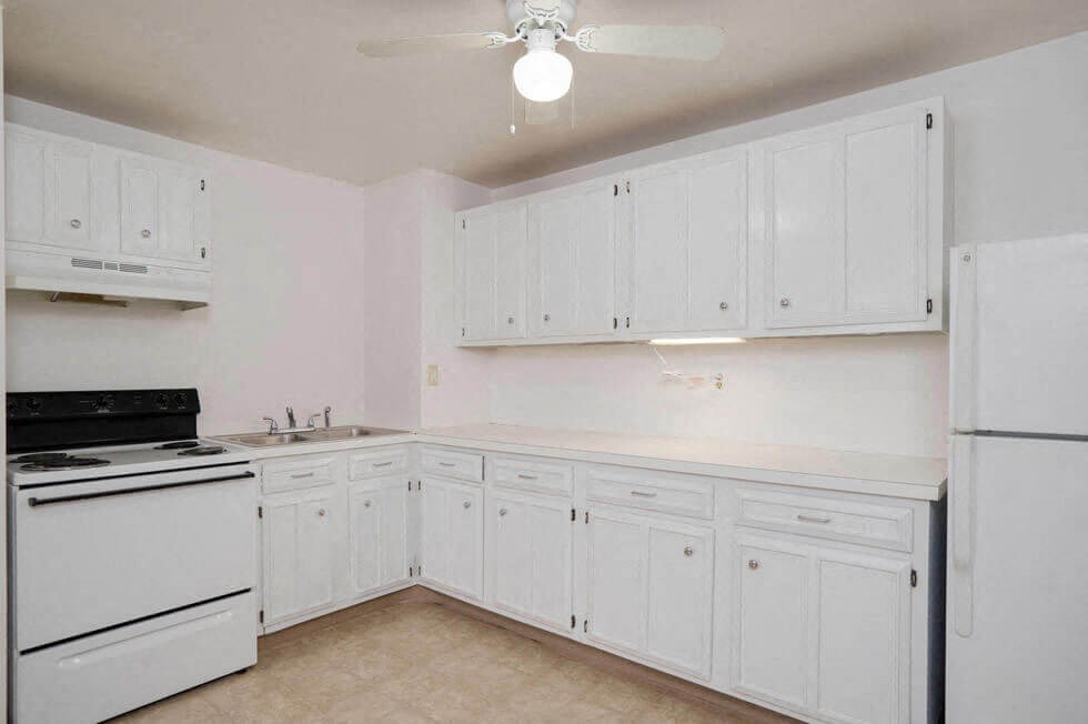a kitchen with white cabinets and a stove and refrigerator
