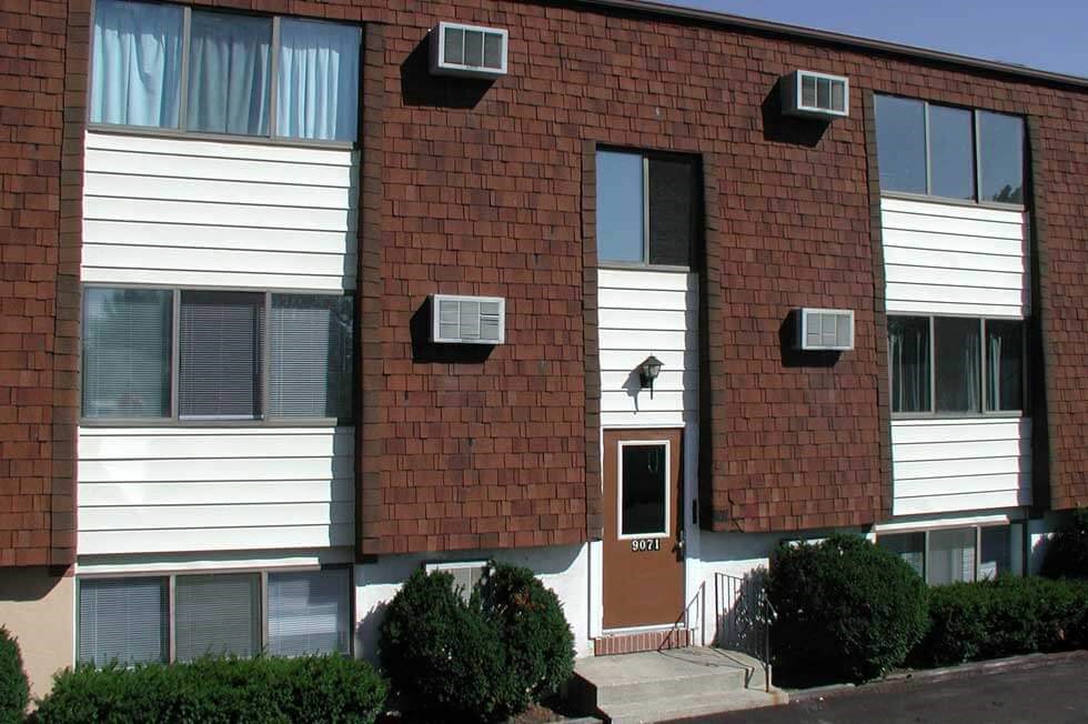 a dog sitting on the window of a brick building