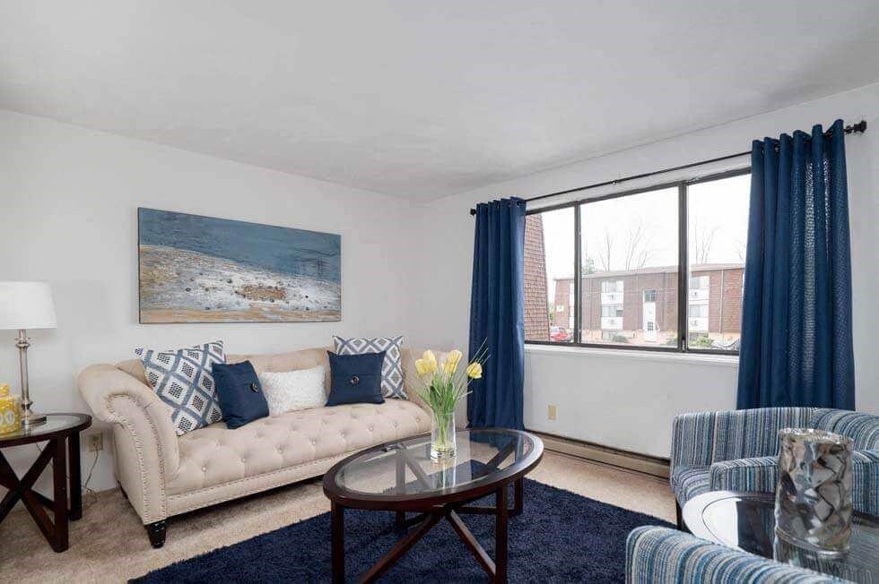 a living room with blue curtains and a couch and a table