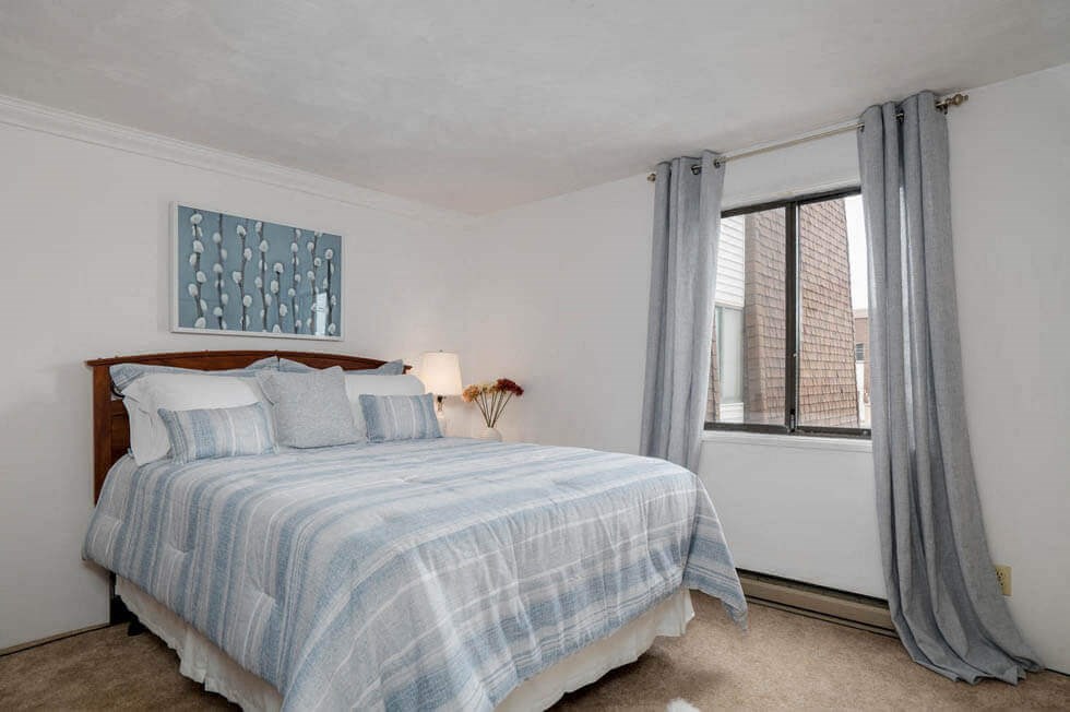 a bedroom with a bed and a large window