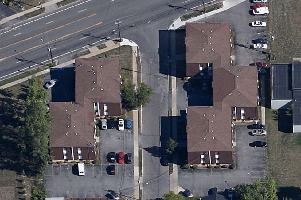 an aerial view of rooftops of houses in a city street