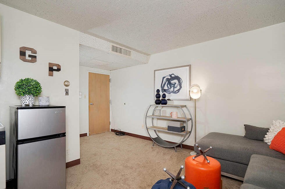 a living room with a couch and a refrigerator