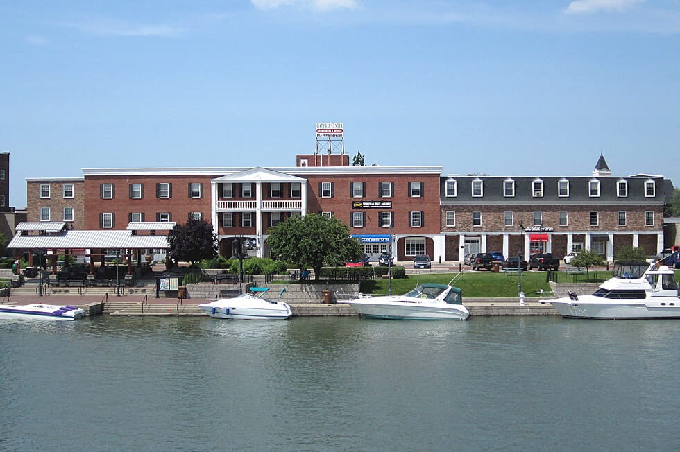 three boats in the water in front of a large building