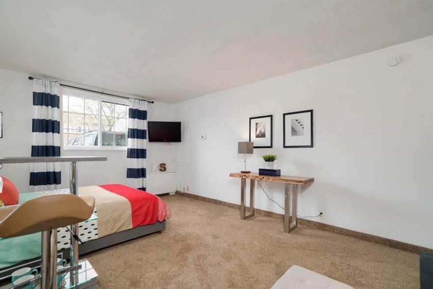 a bedroom with a bed and a desk and a window