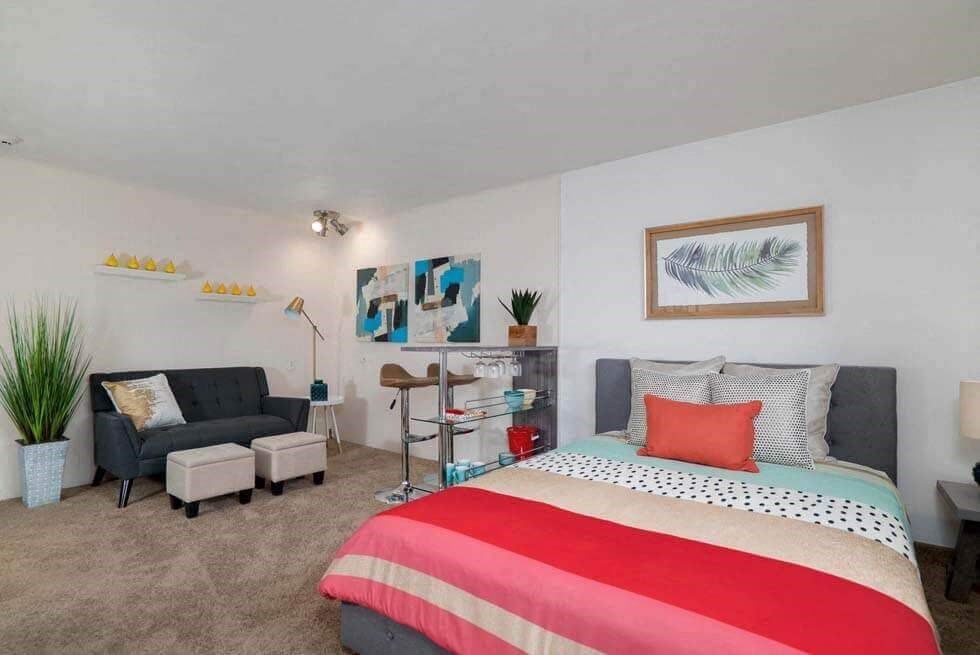 a bedroom with a bed and a couch and a chair