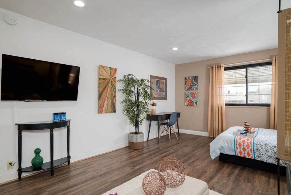a living room with a bed and a tv