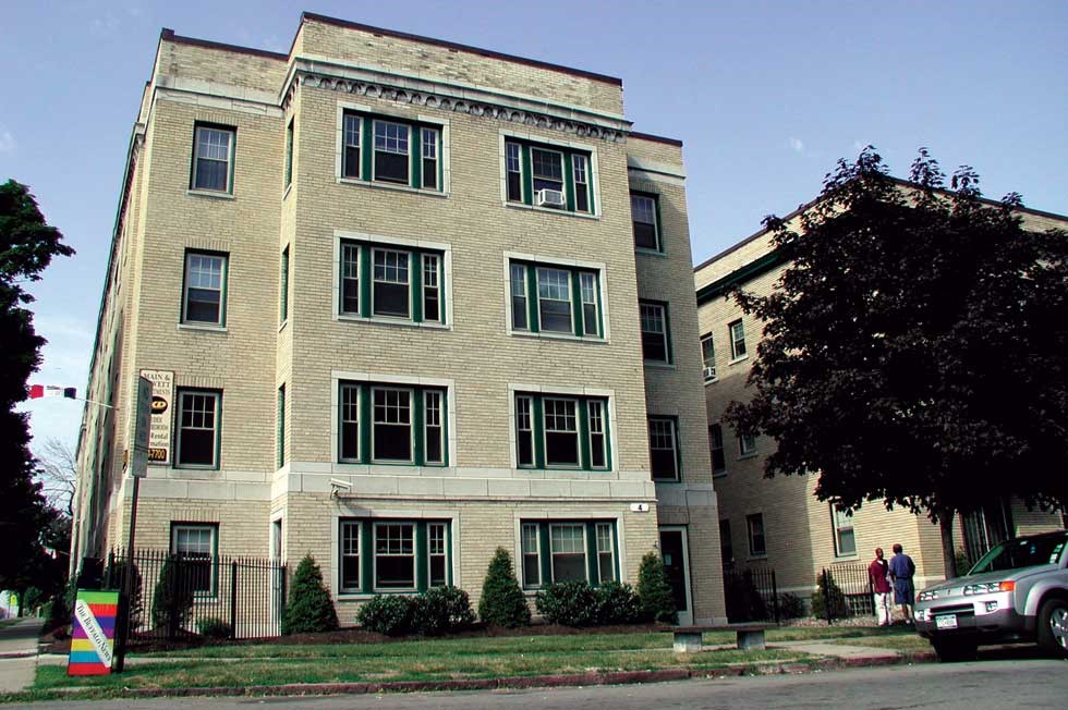a large apartment building with people standing outside of it