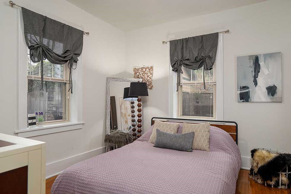 a bedroom with a bed and three windows