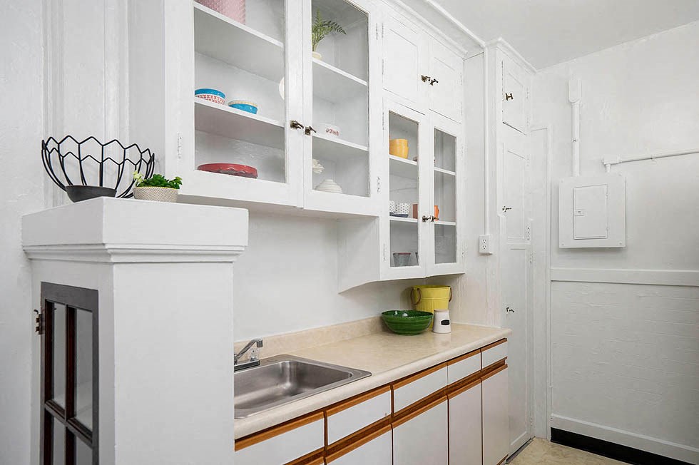 a kitchen with a sink and white cabinets