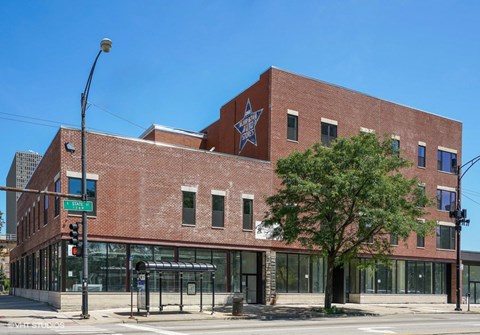 A red brick building with a large star on the top floor.