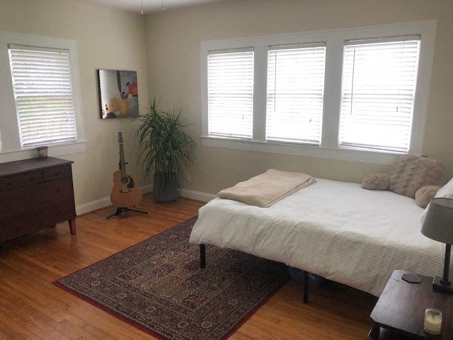 a bedroom with a bed and a guitar in it