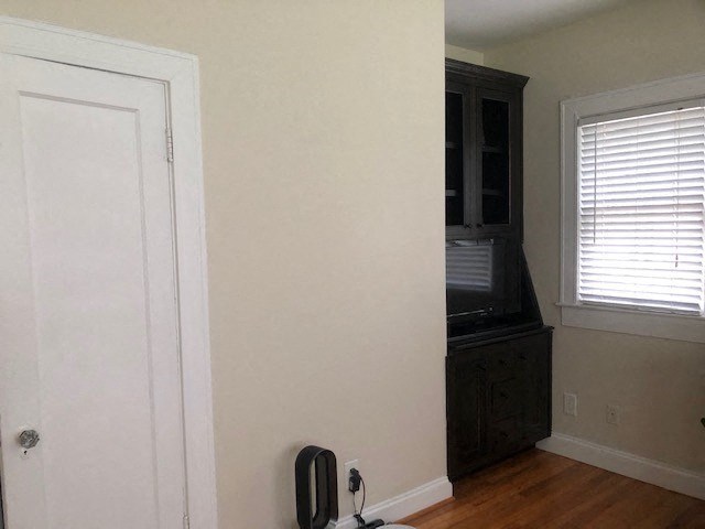 an empty room with a door and a television in it