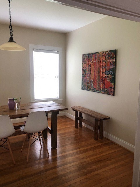 a dining room with a table and a painting on the wall