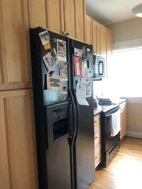 a stainless steel refrigerator in a kitchen with wooden cabinets