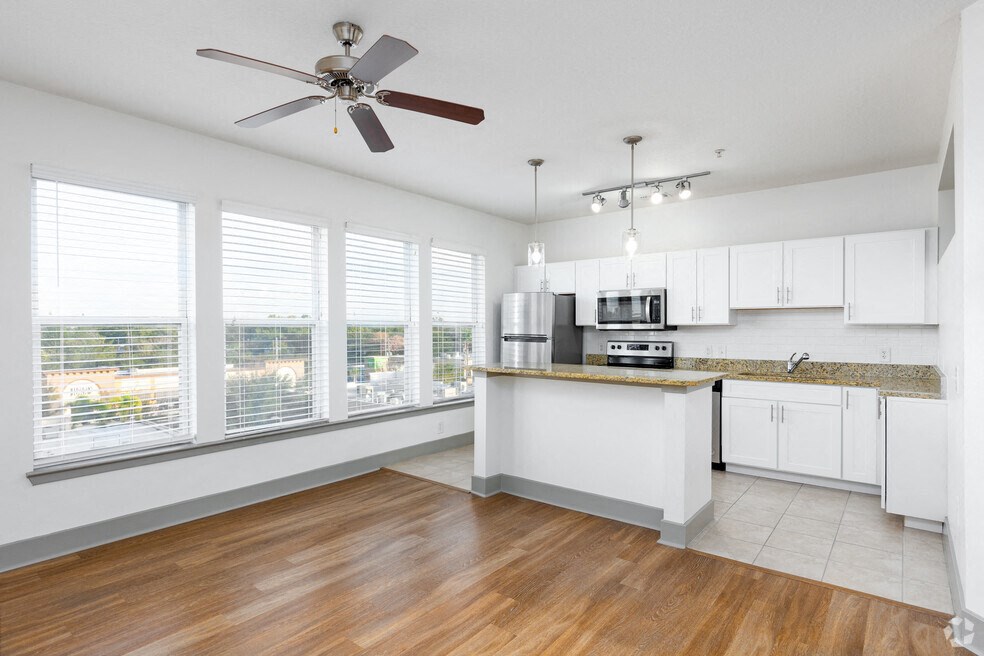 a kitchen with a large window and a ceiling fan