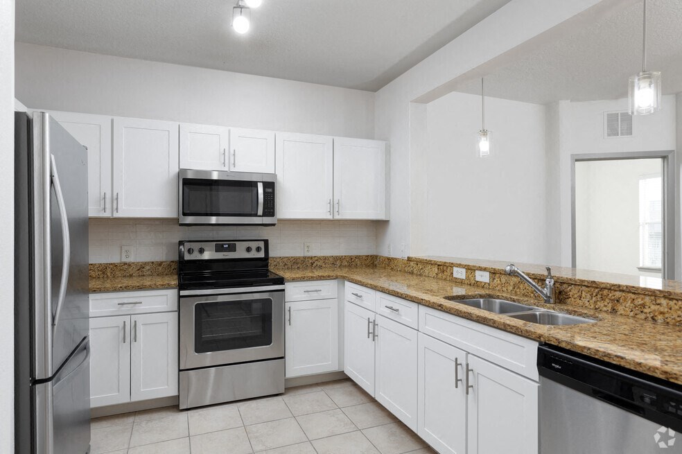 a kitchen with white cabinets and stainless steel appliances