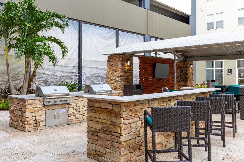 a bar with chairs and a grill outside of a building