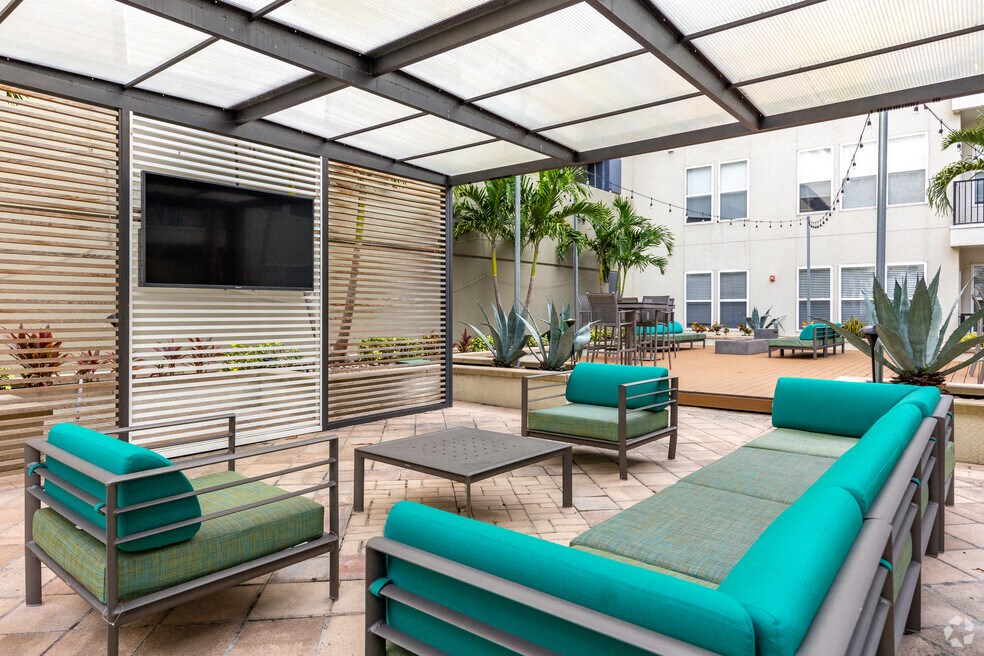 a patio with couches and chairs and a tv