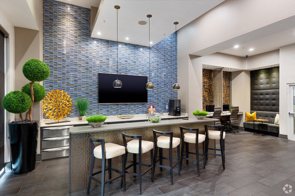 a lobby with a bar with chairs and a television