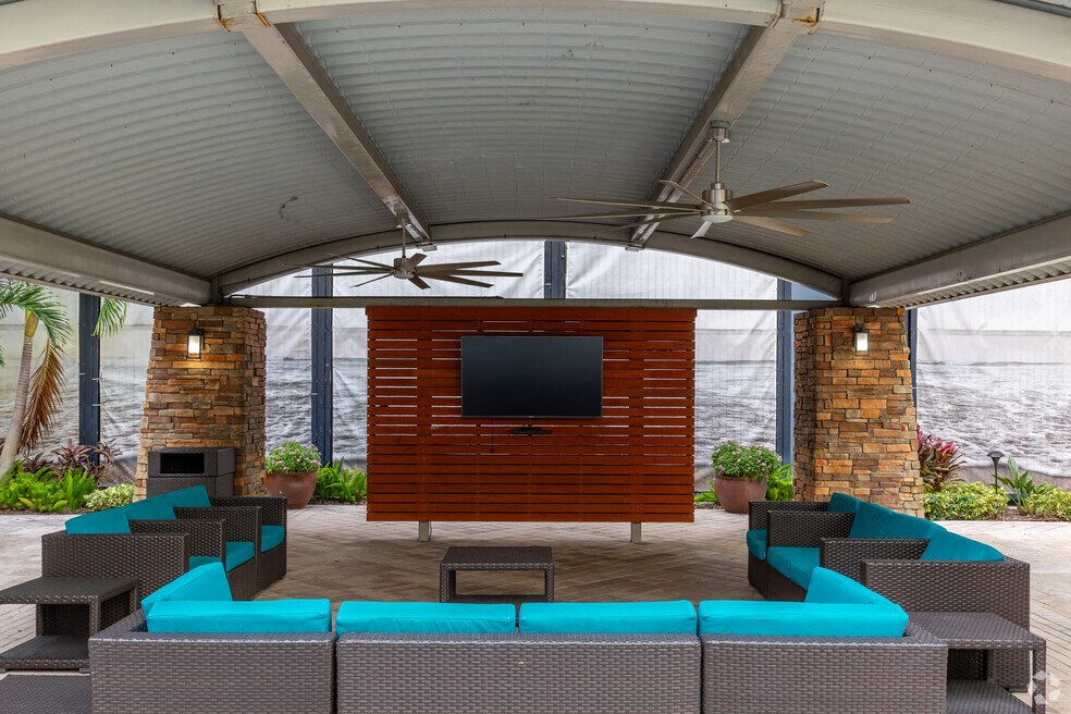 a covered patio with couches and a television