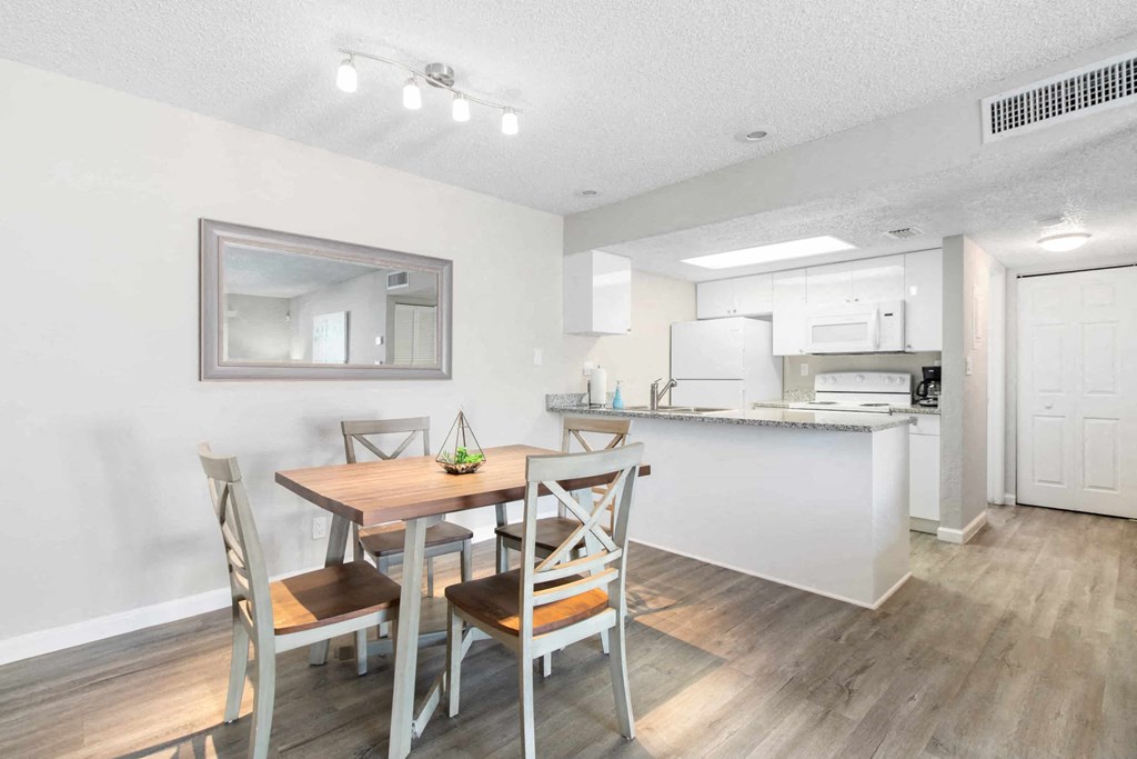 A kitchen with a dining table and chairs.