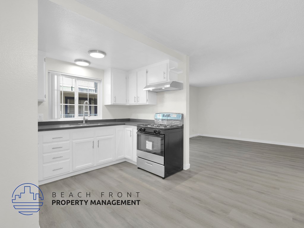 A kitchen with a stove top oven and a window.